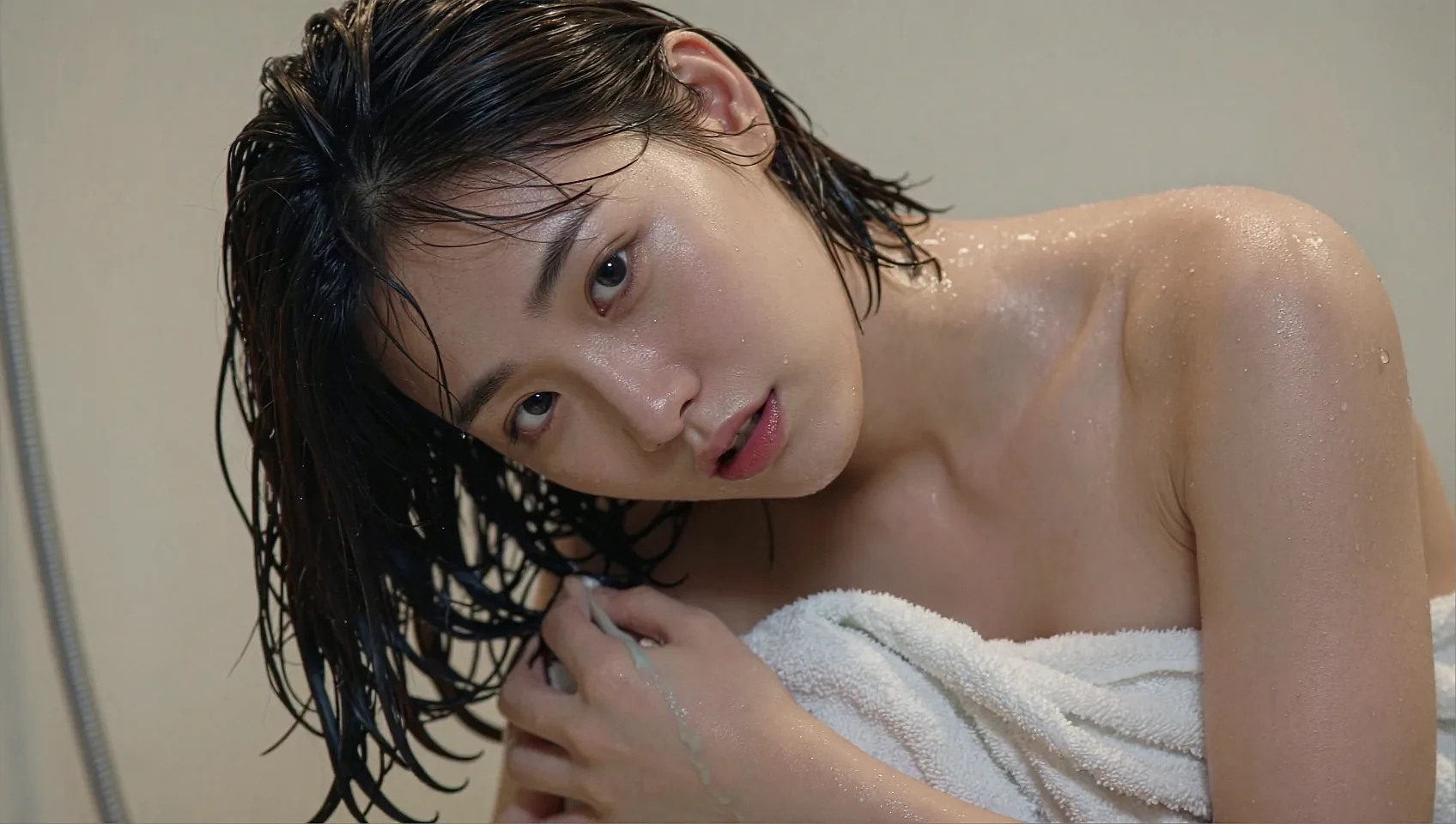 Wide frame of a fictional AI companion wrapped in a towel beside the closing invitation